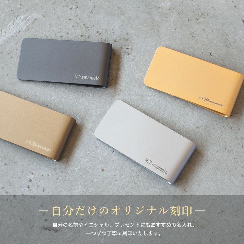 4色の真鍮製マネークリップに「N.Yamamoto」と刻印し、名前やイニシャルを入れられるオリジナル刻印サービスを紹介する画像。