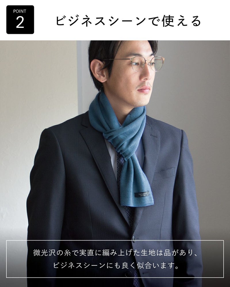 ビジネススーツに青いマフラーを着用した男性。上品な光沢感のある生地で、ビジネスシーンに最適であることを表現。