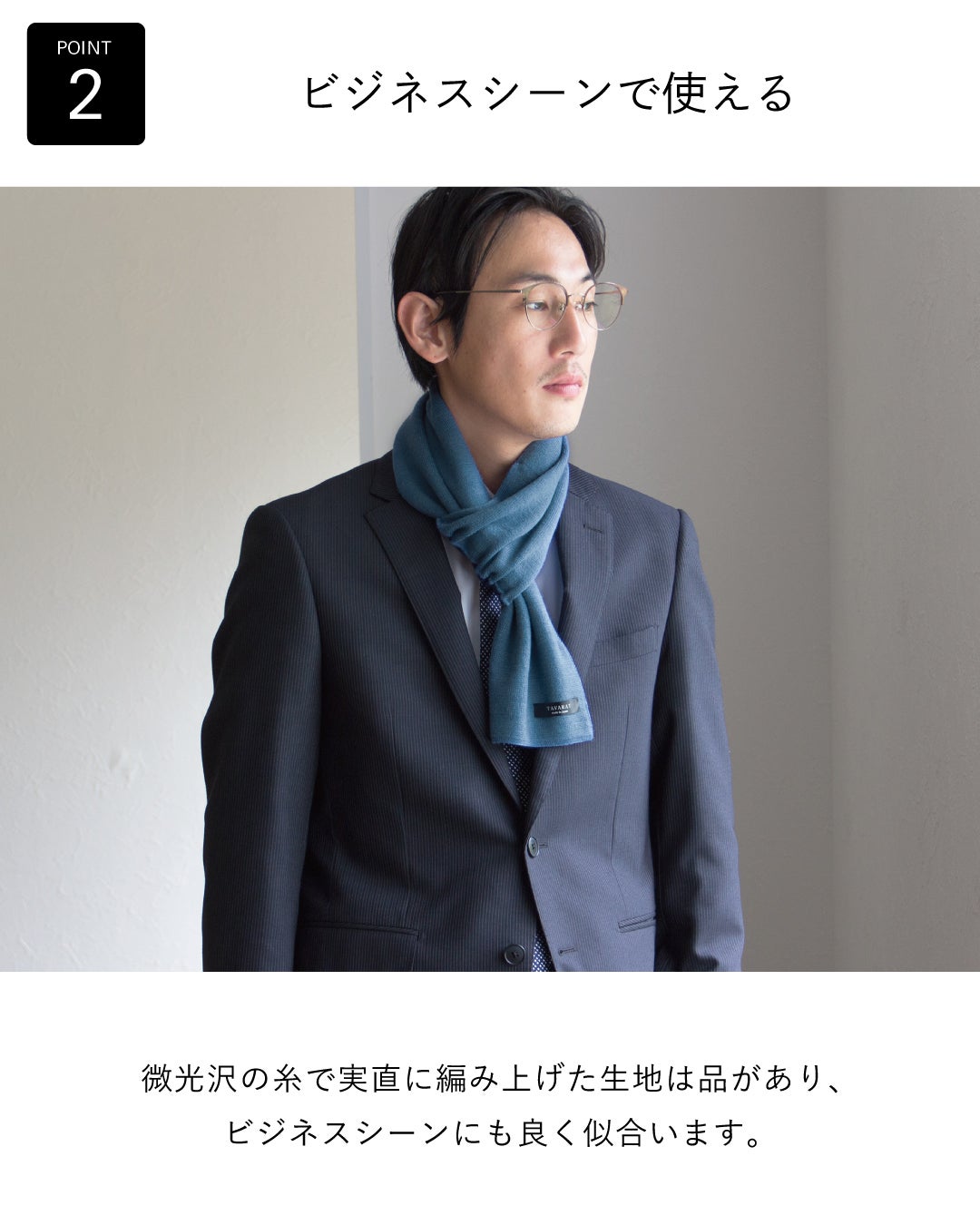 ビジネススーツに青いマフラーを着用した男性。上品な光沢感のある生地で、ビジネスシーンに最適であることを表現。