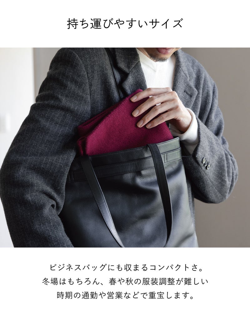 ワインのカシミヤ3秒マフラーを畳んで黒のレザートートにしまう様子で、ビジネスバッグにも収まるコンパクトさが春秋の通勤や営業にも便利なことを紹介。