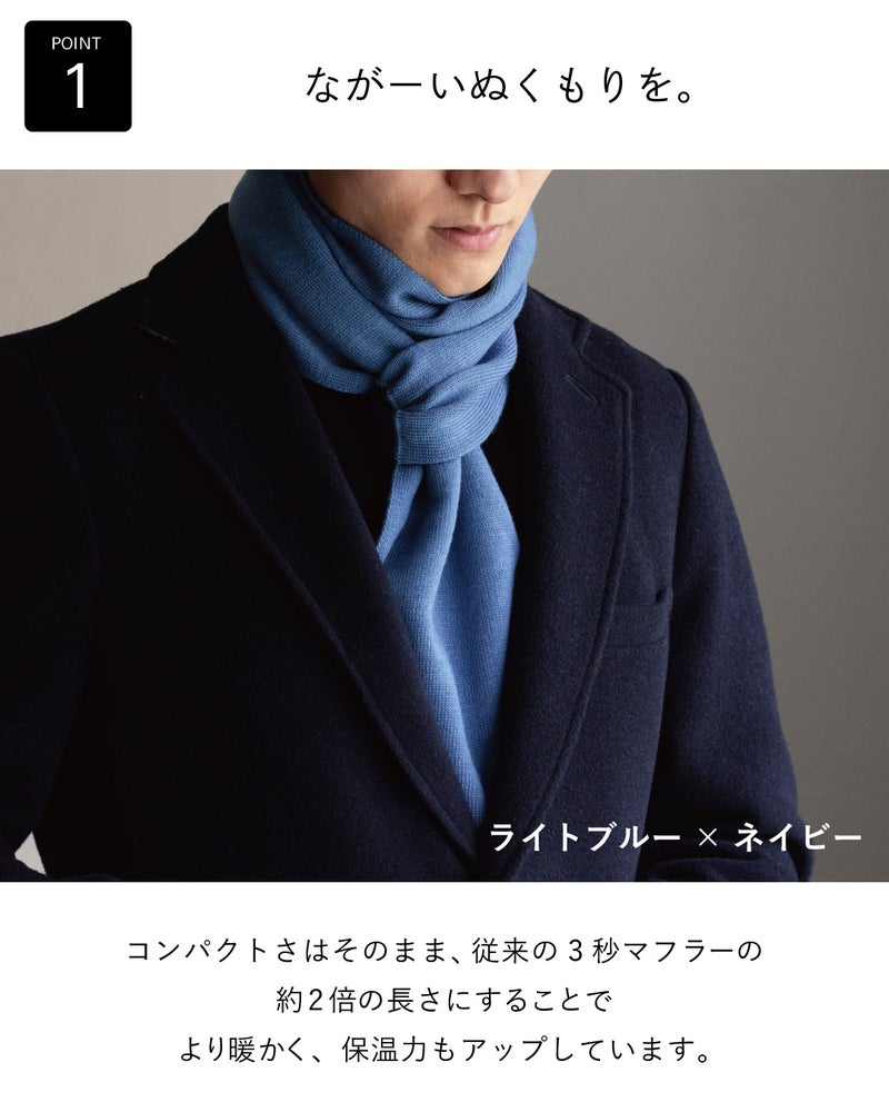 従来の3秒マフラーの約2倍の長さで保温力が高まった、ライトブルー×ネイビーの3秒マフラー ロングをネイビーのコートに重ねて首元を暖かく包む着用例。