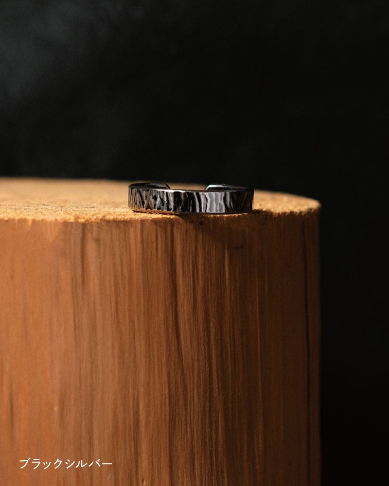 木の台の上に置かれた槌目模様のブラックシルバーリング