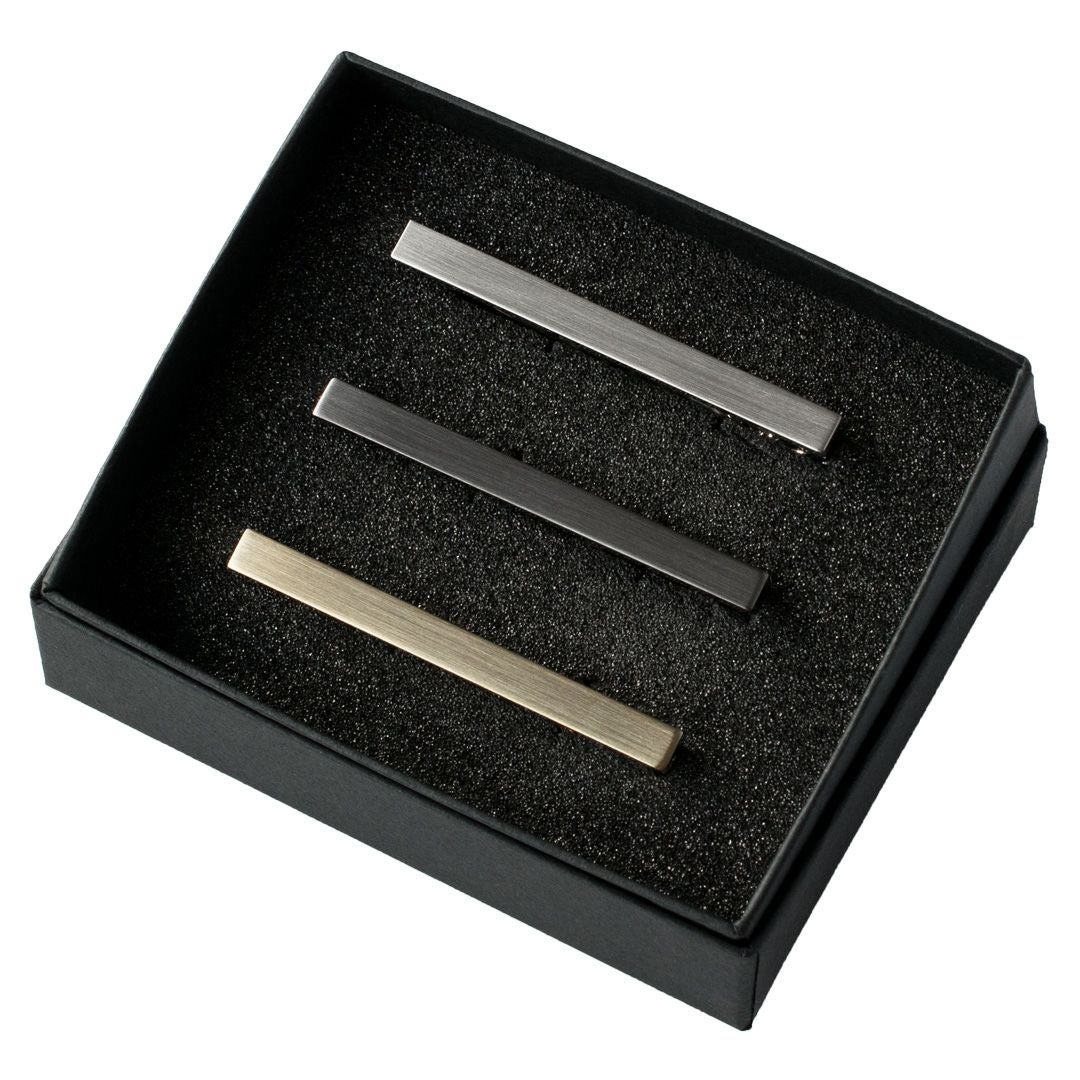 黒い箱に入ったシルバー、ブラックシルバー、ライトゴールドの3色のシンプルなネクタイピンセット。