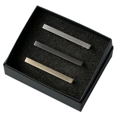 黒い箱に入ったシルバー、ブラックシルバー、ライトゴールドの3色のシンプルなネクタイピンセット。