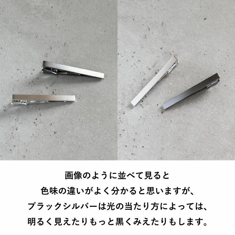 シルバーとブラックシルバーのネクタイピンの色味の比較。光の当たり方による見え方の違いを示す。