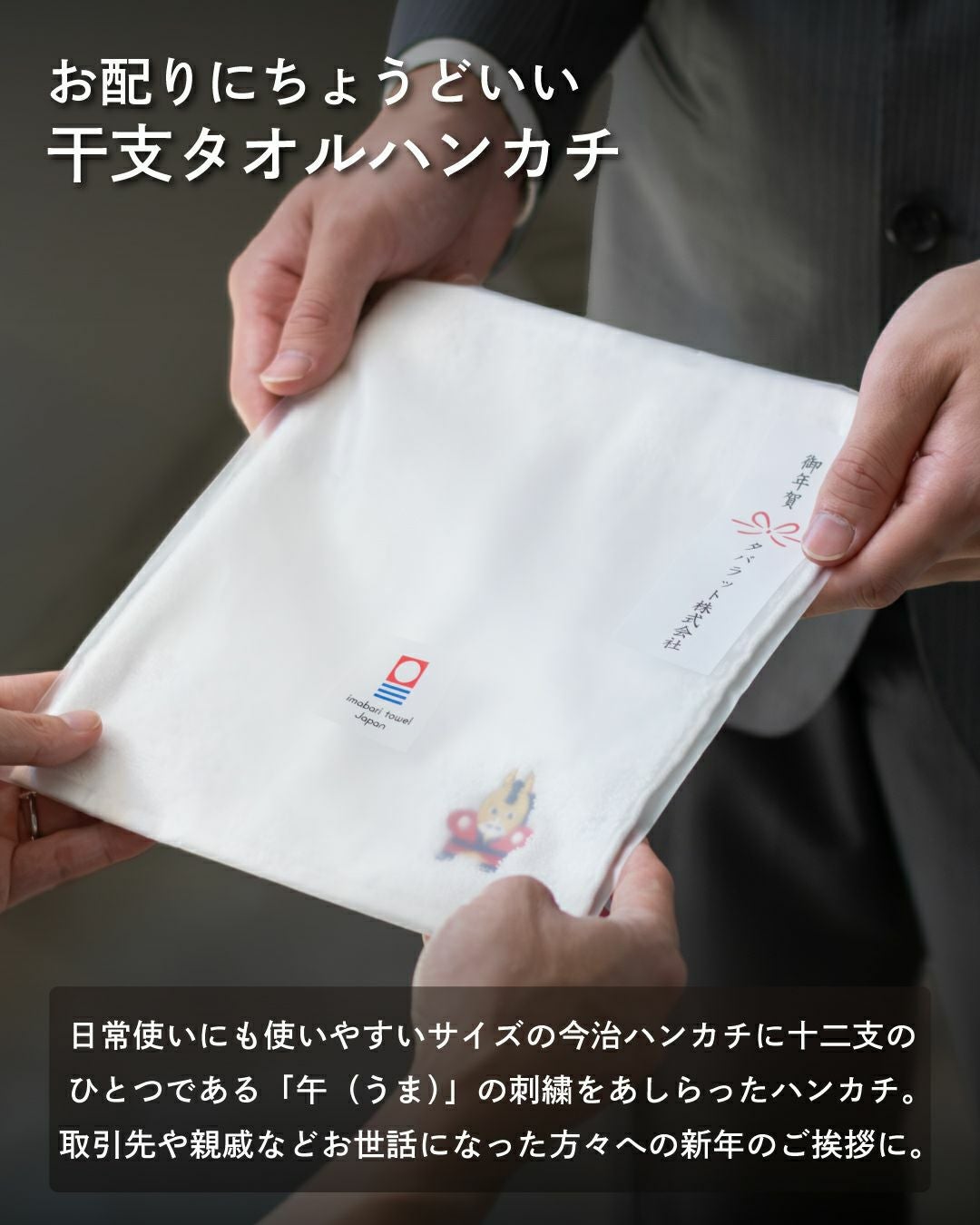新年のご挨拶として、干支（午 うま）の刺繡入りタオルハンカチを手渡す様子。
