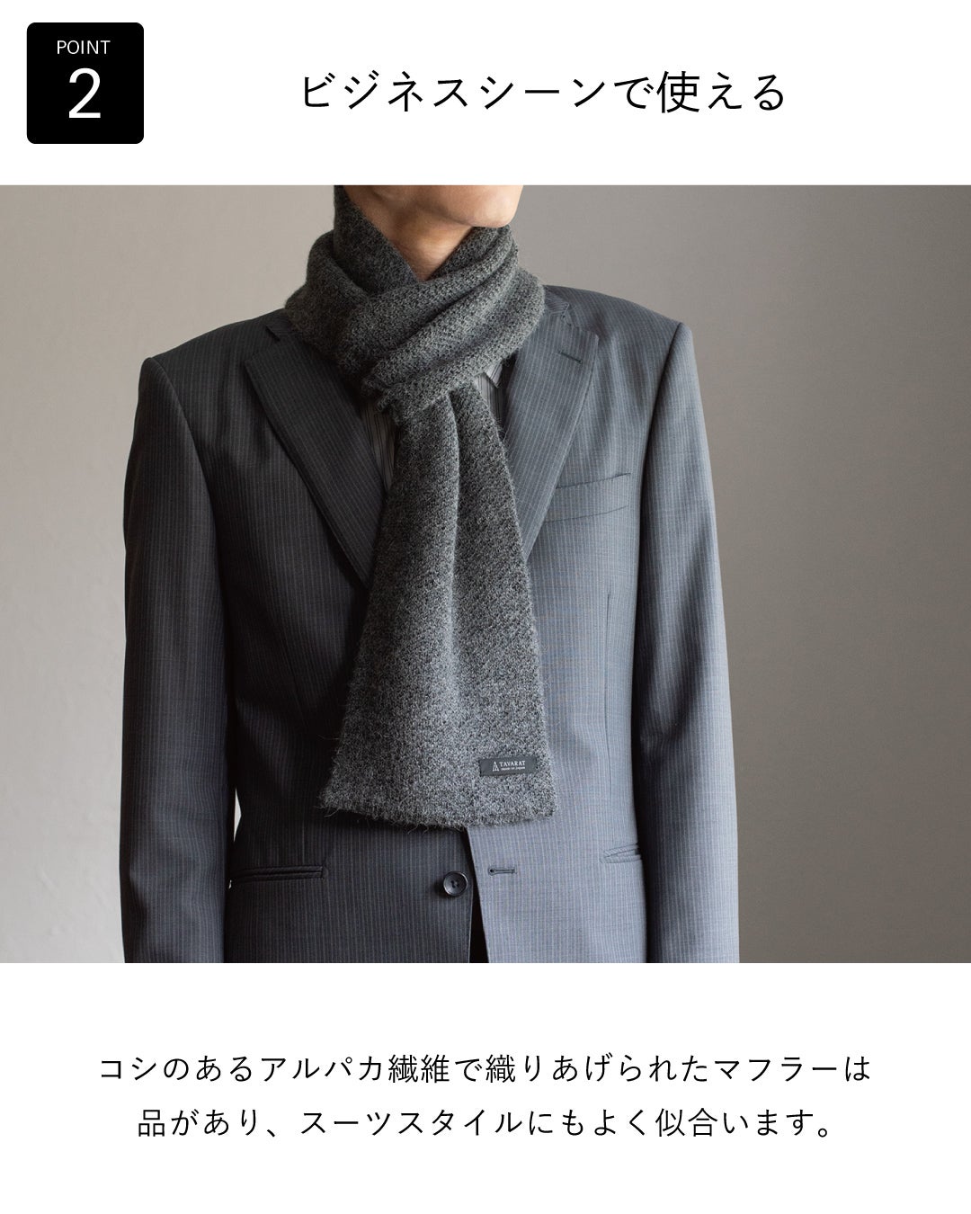 コシのあるアルパカ繊維で織りあげた品のあるグレーのアルパカ 3秒マフラーを、ストライプスーツに合わせてビジネスシーンでの使いやすさを伝える着用例。