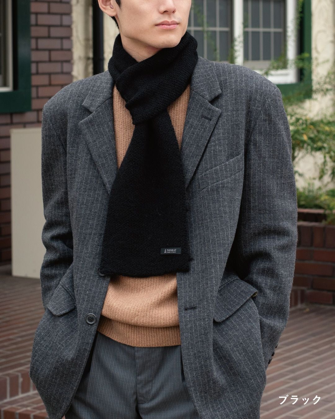 ブラック色のアルパカ100%マフラーを巻いた男性の着こなし。重厚感があり、フォーマルな装いにも合うミニマフラー。