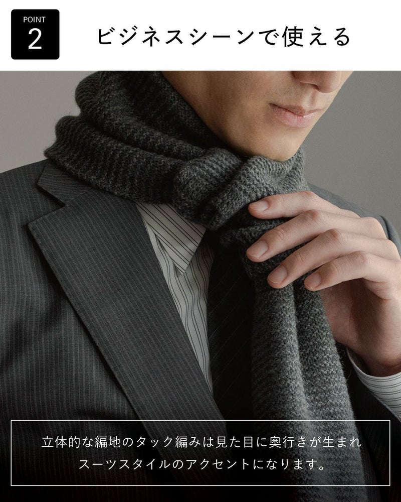 ポイント2：「ビジネスシーンで使える」。立体的なタック編みのグレーマフラーが、スーツスタイルにアクセントを加える様子。