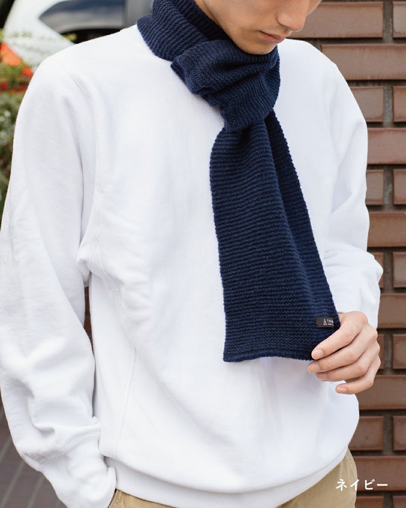ネイビー色のタック編みマフラーを巻いた男性の着こなし。スーツに馴染むビジネス向けのミニマフラー。