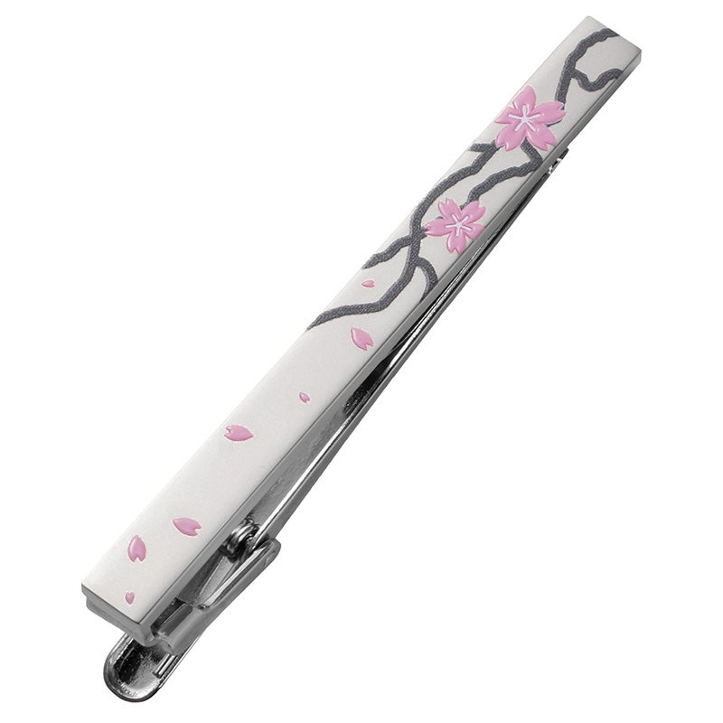 吹雪のデザイン。淡いベージュのベースに、風にそよぐ木の枝と、ピンク色の立体的な桜の花びらが舞う、春らしく優雅な印象のネクタイピン。