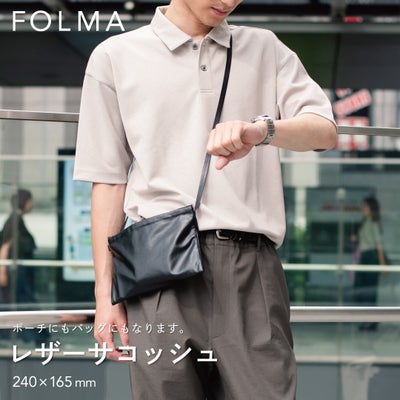 FOLMAレザーサコッシュ（240×165mm）をスーツの脇に斜めがけしたスタイリング。ポーチにもバッグにもなる2WAY仕様のブラックナッパーレザー製サコッシュ。