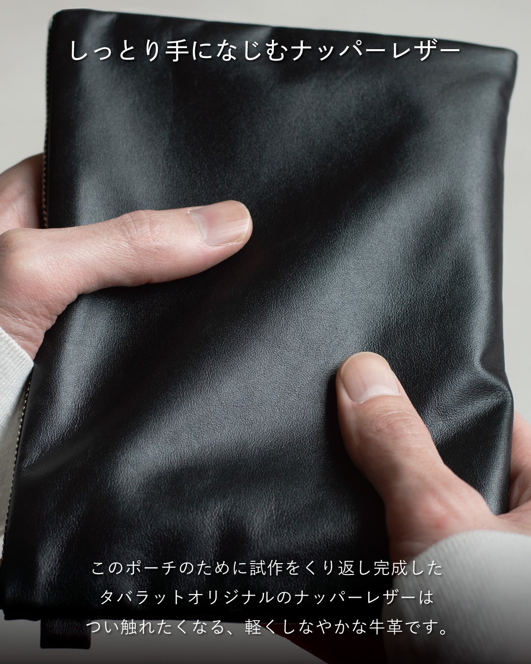 両手で包み込んで持つFOLMAブラックナッパーレザーポーチ。タバラットが試作を重ねて完成させたオリジナル牛革のしっとりしなやかな手触りを訴求するビジュアル。