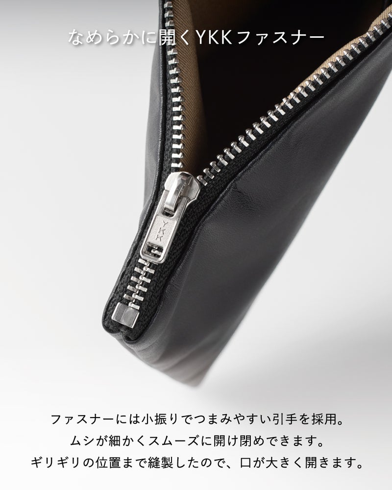 FOLMAレザーポーチのコーナー部分に装着されたYKKシルバーメタルファスナーの引き手クローズアップ。ブラックレザーに映えるシルバーの歯列となめらかな開閉感を表現。