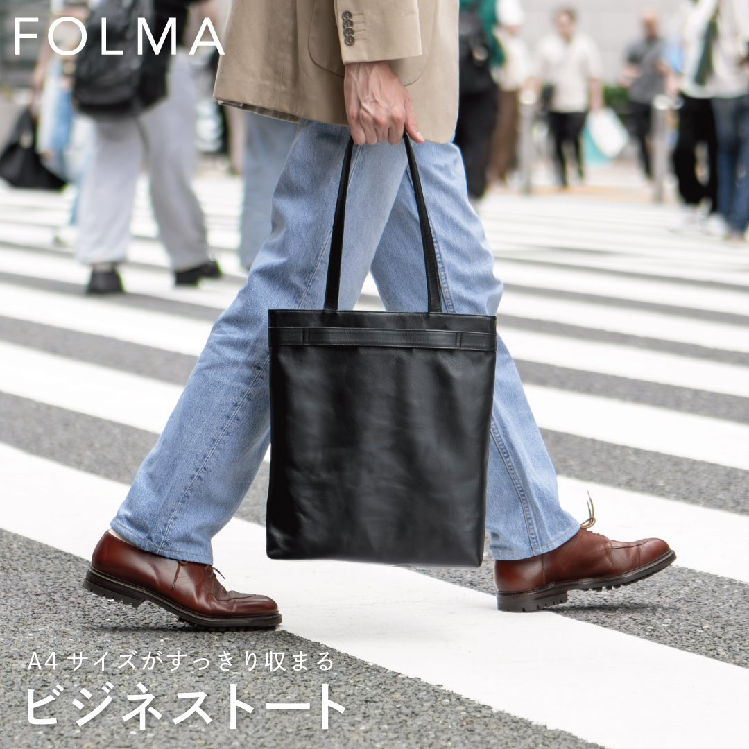 街中の横断歩道でFOLMAビジネストートを持ち歩くビジネスマンの姿から、A4サイズも余裕で収まる本革製トートの実用性が伝わるスナップ。