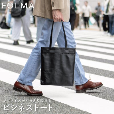 街中の横断歩道でFOLMAビジネストートを持ち歩くビジネスマンの姿から、A4サイズも余裕で収まる本革製トートの実用性が伝わるスナップ。