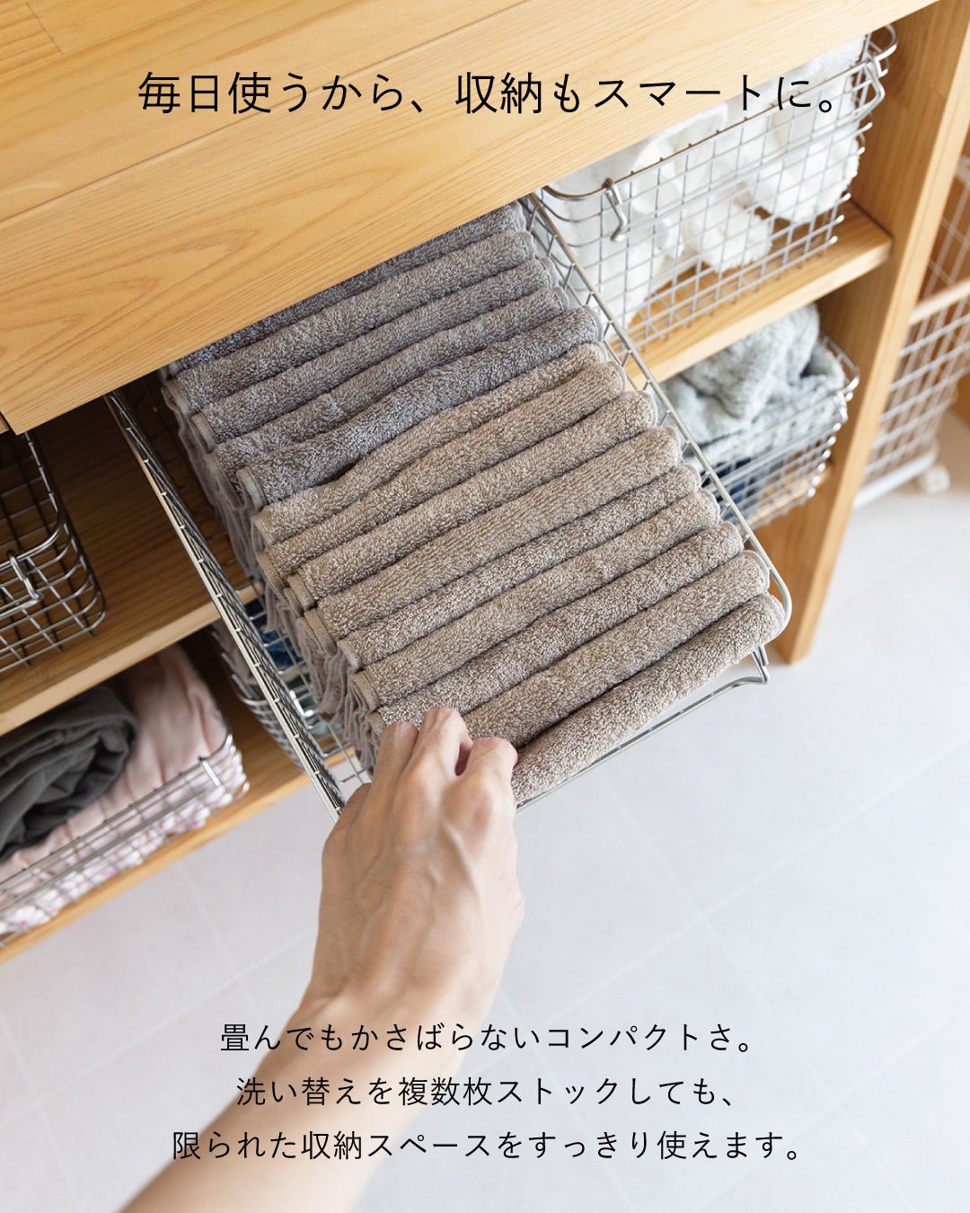 畳んだベージュとグレーのちょうどいいフェイスタオルをワイヤーバスケットに重ねて収納し、コンパクトな洗い替えストックを紹介。
