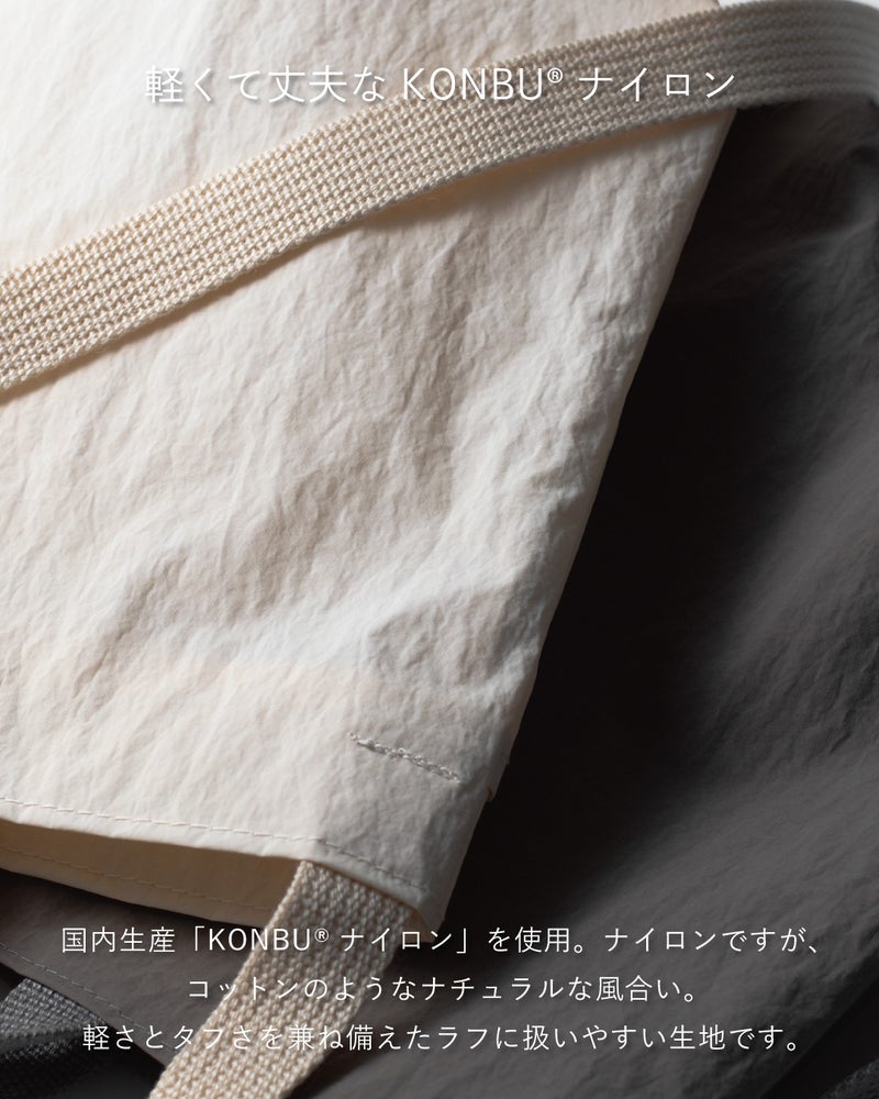 アイボリー生地とコットン調のKONBU®ナイロン素材のアップで、軽さと丈夫さを兼ね備えた国内生産生地の風合いを伝えるクローズアップ写真。