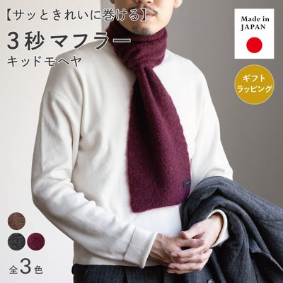 白ニットにワインの3秒マフラー キッドモヘヤを巻いた男性の着用イメージで、日本製・全3色展開、TVRTのギフトラッピングにも対応。