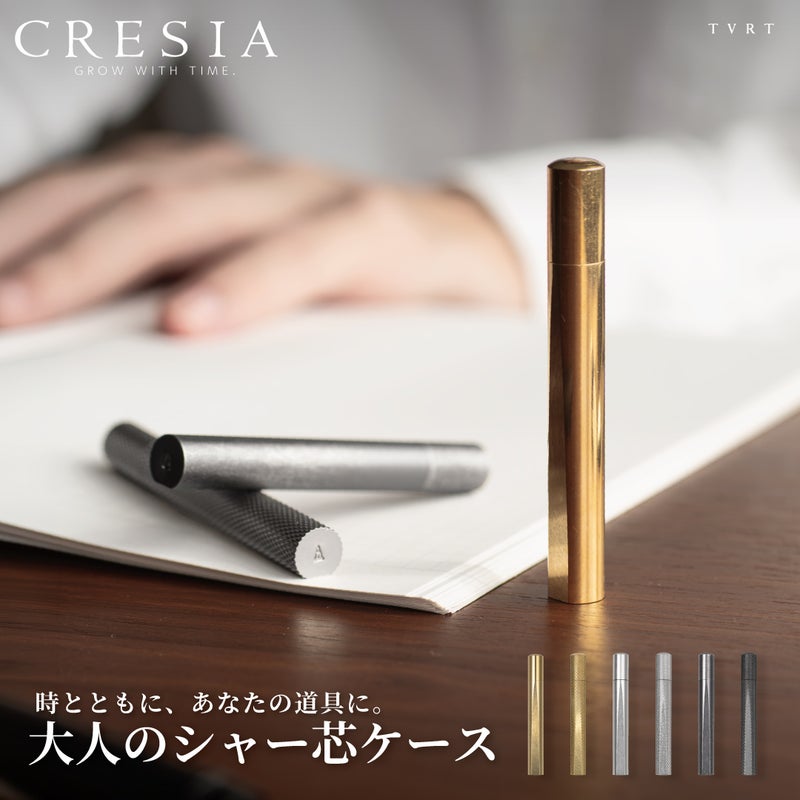 ノートの上に立てたブラスと寝かせたシルバー・ブラックのCRESIA シャー芯ケース、全6種のバリエーション一覧